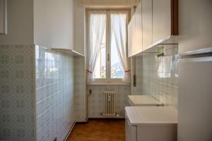 a small kitchen with a window and a sink at Verbania Panorama Lago in Verbania +2 photos