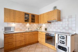 a kitchen with wooden cabinets and a stove top oven at Kati´s Haus in San Pancrazio dʼUltimo