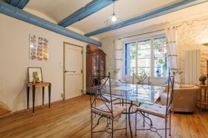 a dining room with a glass table and chairs at Laho - Chambre d'hôte in Lagorce