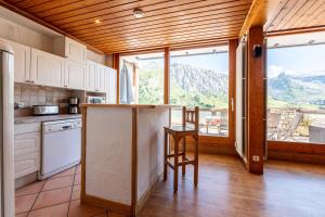 a kitchen with a counter and a table and a window at Shamrock 2B in Tignes