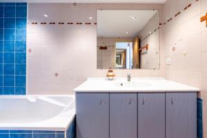 a bathroom with a tub and a sink and a bath tubermottermott at Shamrock 2B in Tignes +22 photos