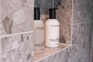 three bottles of soap sitting on a shelf in a bathroom at 4 Personen Apartment 47 in Überlingen