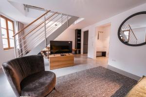 a living room with a chair and a television at 4 Personen Apartment 47 in Überlingen