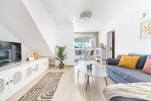 a living room with a blue couch and a tv at Pomelo vacacional in Arguineguín