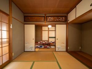 a japanese room with glass doors and a room with a bed at 小豆島宿いたち in Tonosho