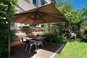 a table and chairs under an umbrella on a deck at Schlafen im historischen Haus in Weier