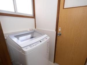 a laundry room with a washing machine and a door at 小豆島宿いたち in Tonosho