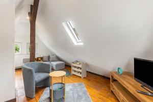 a living room with a couch and a tv and a chair at Ferienhaus Feußner in Lauterbach