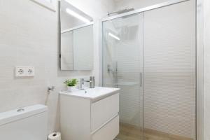 a white bathroom with a sink and a shower at Apartamento Calderon in Barbate +18 photos