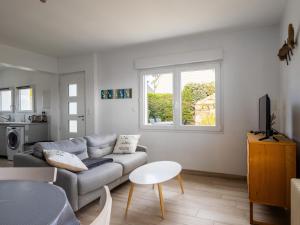 a living room with a couch and a table at Ti Ma Zud Bihan in Pleumeur-Bodou