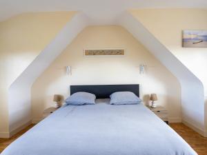 a bedroom with a large bed with blue pillows at Ti Ma Zud Bihan in Pleumeur-Bodou