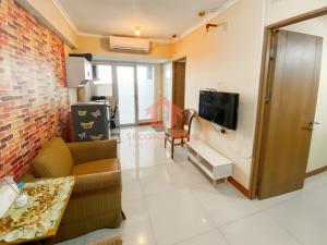 a living room with a couch and a tv at Cozy 2BR Bintaro Park View Pool in Jakarta