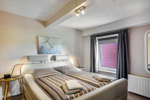 a bedroom with a large bed and a window at Ferienhof Harrsen in Pellworm
