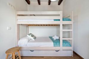 a bedroom with bunk beds with a chair and a stool at Loft Jb in L'Ametlla de Mar