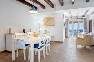 a white dining room with a white table and chairs at Loft Jb in L'Ametlla de Mar +15 photos