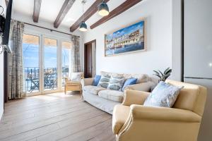 a living room with a couch and chairs and a balcony at Loft Jb in L'Ametlla de Mar