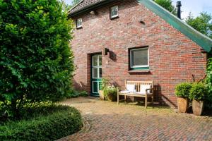 a brick house with a bench in front of it at Ferienhaus Neudorf in Varel