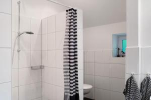 a white bathroom with a shower and a toilet at Ferienhaus Neudorf in Varel +22 photos