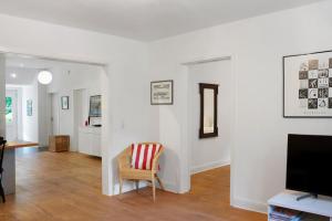 a living room with a chair and a flat screen tv at Ferienhaus Neudorf in Varel