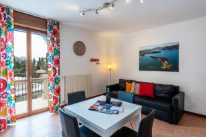 a living room with a table and a couch at Villa Bornico Margherita in Toscolano Maderno