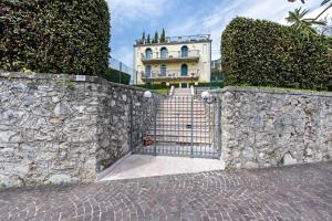 a stone wall with a gate in front of a building at Villa Bornico Margherita in Toscolano Maderno