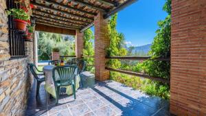 a patio with a table and chairs on a brick building at Las Gallinas Cottage Orgiva in Órgiva