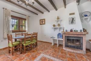 a living room with a fireplace and a table and chairs at Las Gallinas Cottage Orgiva in Órgiva