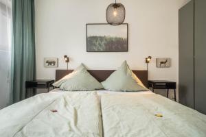 a bedroom with a white bed with two pillows at Heimelig im Hirschen App 117 in Schönwald +28 photos