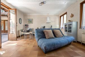 a living room with a blue couch and a kitchen at studio maupas in Vienne