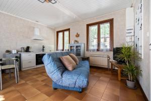a living room with a blue couch and a kitchen at studio maupas in Vienne +15 photos