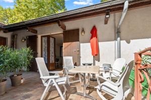 a patio with white chairs and a table and umbrella at studio maupas in Vienne