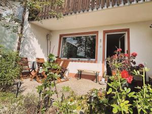 a patio with two chairs and a bench and flowers at Ferienwohnung Bienenkorb in Selb