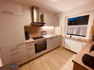 a kitchen with white cabinets and a sink and a window at Ferienwohnung Bienenkorb in Selb +17 photos