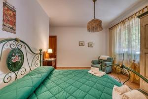 a bedroom with a green bed and a chair at Villa Del Riccio in Magione