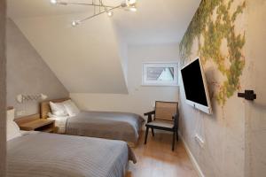 a room with two beds and a tv on the wall at Heimelige Schwarzwaldwohnug Berg in Häusern