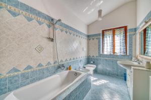 a bathroom with a tub and a sink and a toilet at Villa Del Riccio in Magione +31 photos