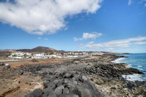 a rocky beach with houses and the ocean at La Casa de Maika in Guatiza