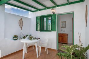 a dining room with a white table and chairs at La Casa de Maika in Guatiza
