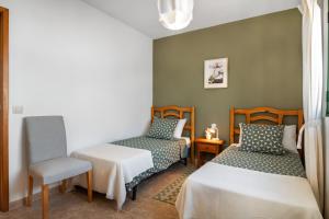 a room with two beds and a chair at La Casa de Maika in Guatiza