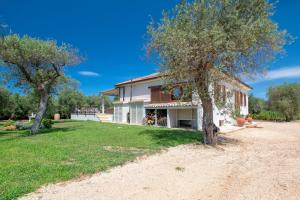 a house with two trees in front of it at Villa Olivetta con piscina in Alghero