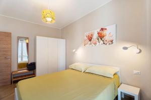 a bedroom with a bed and a painting on the wall at Casa Làrisa Lago Maggiore in Laveno-Mombello