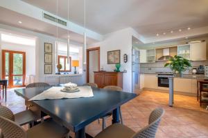 a kitchen and dining room with a table and chairs at Villa Olivetta con piscina in Alghero