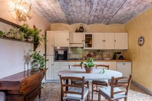 a kitchen with a table and chairs and a ceiling at Podere La Speranza in Chiusdino
