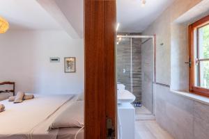 a bedroom with a bed and a bathroom with a shower at Podere La Speranza in Chiusdino +25 photos