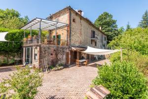 an old building with a tent in front of it at Podere La Speranza in Chiusdino