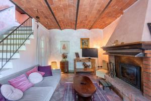 a living room with a couch and a fireplace at Podere La Speranza in Chiusdino