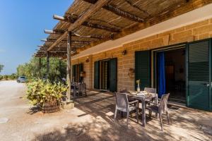 a patio with a table and chairs and a building at Domus mea salento Arazzo Blu in Ugento