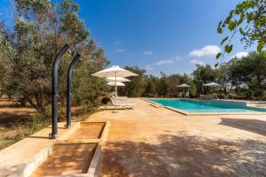 a swimming pool with an umbrella and a table and chairs at Domus mea salento Arazzo Blu in Ugento +19 photos