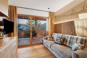 a living room with a couch and a television at Lechnerhof - Clara´s Mountain Lodge in Rodengo