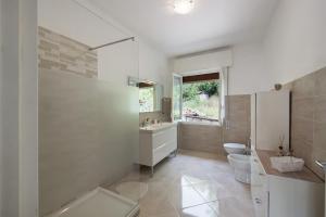 a bathroom with a sink and a toilet and a window at Villino Chiara in Pannesi